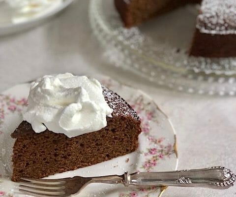 wedge of gingerbread cake with whipped cream